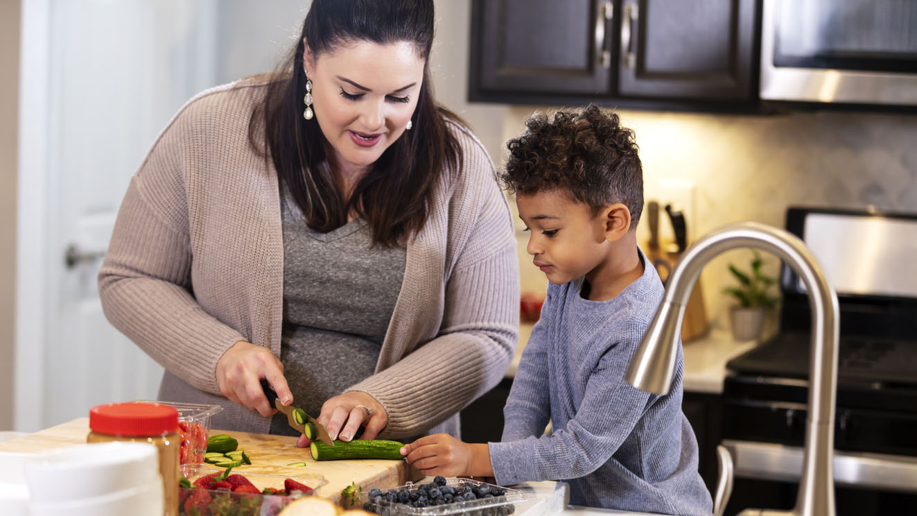 Mother and young son preparing vegetables in the kitchen