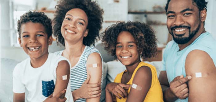 Familia mostrando sus brazos con curitas despu&eacute;s de recibir su vacuna.
